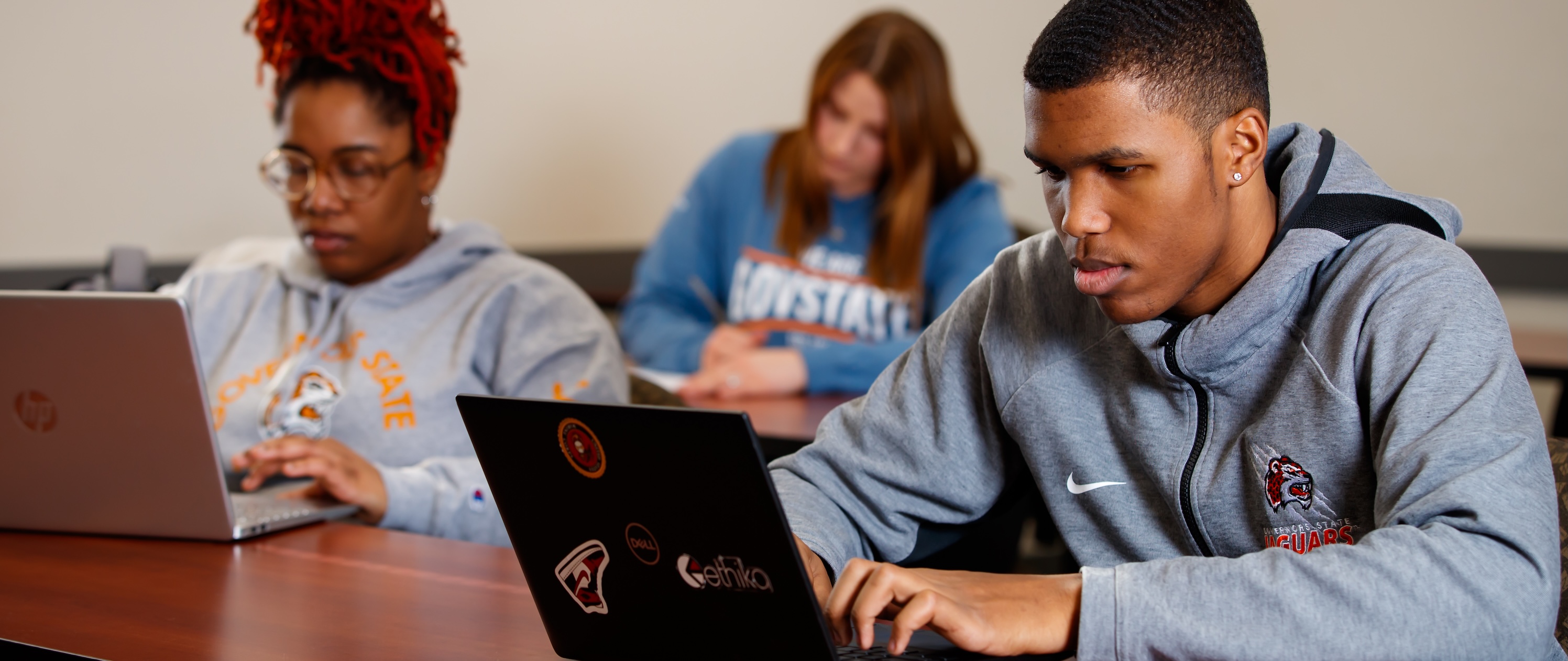 Students typing on laptops in classroom